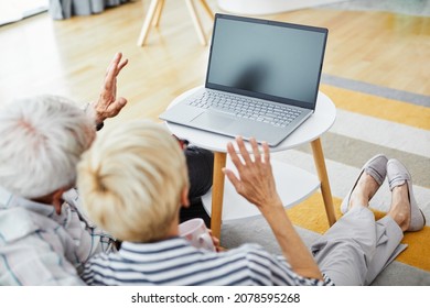 Senior Couple Having Video Call With Family Grandchildren Or Doctor On Laptop At Home