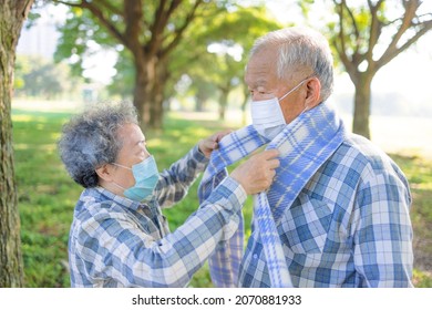 Senior Couple Help Each Other Wearing Warm Winter Cloth