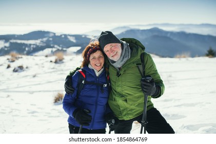 Senior couple hikers with nordic walking poles in snow-covered winter nature. - Powered by Shutterstock