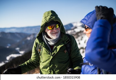 Senior Couple Hikers Talking In Snow-covered Winter Nature.