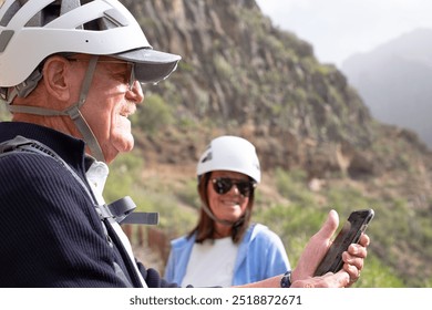 Senior couple hikes with protective helmets enjoying trekking day on mountain. Freedom, healthy lifestyle, success sport concept - Powered by Shutterstock