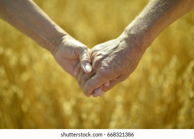 senior couple holding hands together