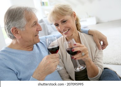 Senior Couple At Home Drinking Red Wine