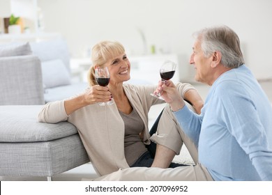 Senior Couple At Home Drinking Red Wine