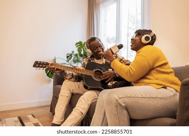 senior couple at home singing and playing guitar - Powered by Shutterstock