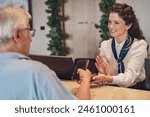 A senior couple at the hotel front desk makes contactless payments with a smartphone. Seniors traveling and using new technologies