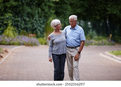 Senior couple, hug and walking with love in neighborhood for bonding, support or retirement together. Elderly, man and woman with care, embrace or commitment for stroll, pension or morning in nature - Powered by Shutterstock