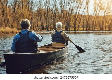 Senior couple, kayak and rowing in river for holiday, travel or summer vacation in water outdoor together. Man, woman or canoe boat in lake on transport for adventure, exercise or back view in nature - Powered by Shutterstock