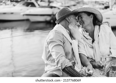 Senior Couple Kissing On Boat During Summer Vacation - Focus On Woman Face - Black And White Editing