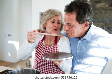 Senior couple in the kitchen cooking together. - Powered by Shutterstock