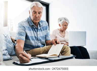 Senior couple, laptop and serious with writing on document in sofa for retirement or shopping list for household. People, planning and budgeting at home for savings, insurance and asset management - Powered by Shutterstock