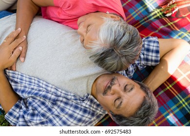 Senior Couple Laying On Blanket At The Park