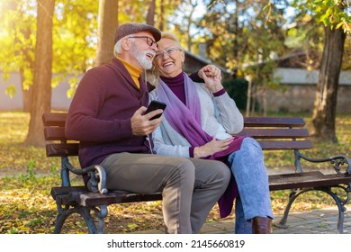 An senior couple listening to music on a bench - Powered by Shutterstock