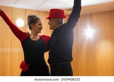 senior couple looking at each other posing for dance class in dance workshop for retirees - Powered by Shutterstock