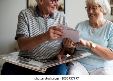 Senior Couple Looking At Family Photo Album