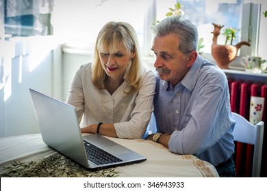 Senior Couple Looking At Laptop 