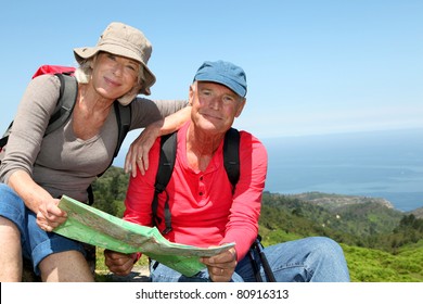 Senior Couple Looking At Map On Hiking Day