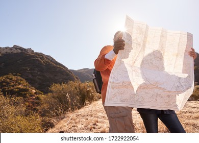 Senior Couple Looking At Map As They Hike Along Trail In Countryside Together - Powered by Shutterstock