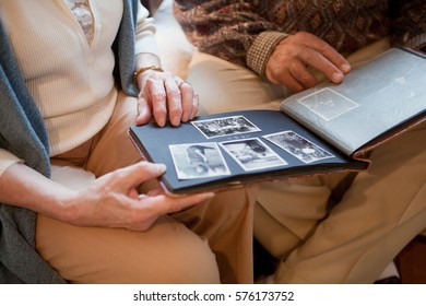 Senior Couple Looking Through Photo Album, Mid Section