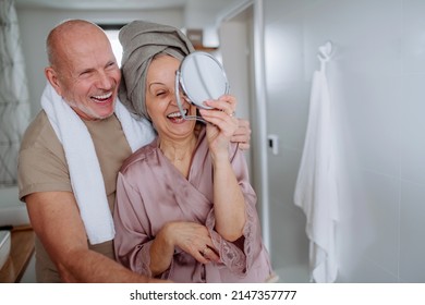 Senior Couple In Love In Bathroom, Looking At Mirror And Smiling, Morning Routine Concept.