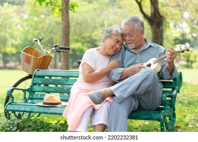 senior couple in love and playing ukulele in a park - Powered by Shutterstock