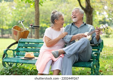 senior couple in love and playing ukulele in a park - Powered by Shutterstock