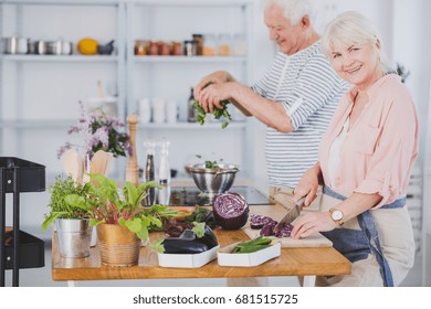 Senior couple making salad in the kitchen - Powered by Shutterstock