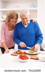 Senior Couple Making Sandwich In Kitchen