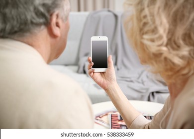 Senior Couple Making Video Call From Mobile Phone At Home