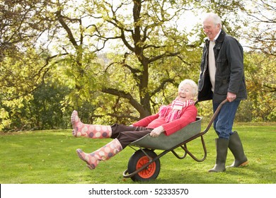 Senior Couple Man Giving Woman Ride In Wheelbarrow - Powered by Shutterstock