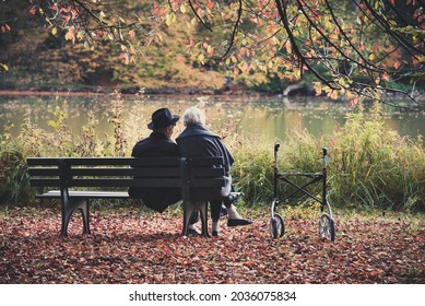 Senior couple man and woman are resting on a bench in the autumn park. Nymphenburg Palace Park in Munich in Bavaria, southern Germany. - Powered by Shutterstock