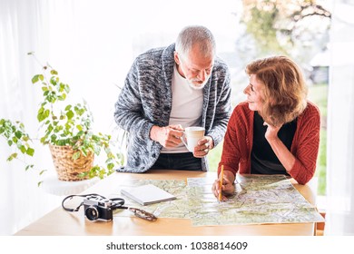 Senior Couple With Map At Home, Making Plans.