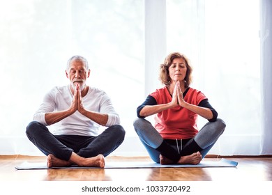 Senior couple meditating at home. - Powered by Shutterstock