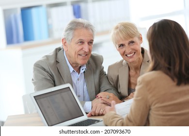 Senior couple meeting financial adviser in office