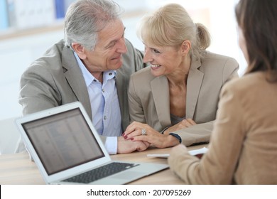 Senior Couple Meeting Financial Adviser In Office