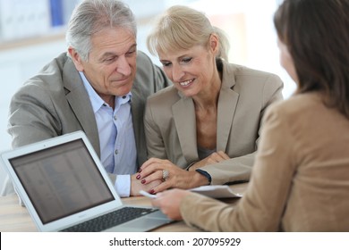 Senior Couple Meeting Financial Adviser In Office