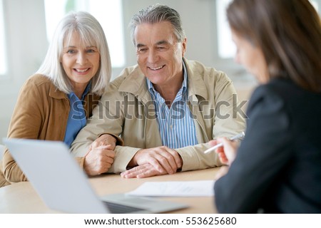 Senior couple meeting financial adviser for investment                