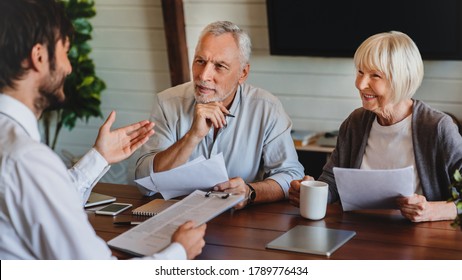 Senior couple meeting with male financial advisor or insurance agent at home