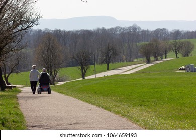 senior couple with motordriven wheelchair on blue sky sunny holiday at eastern springtime in south germany