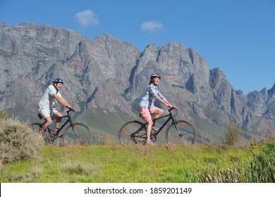 Senior Couple Mountain Biking On A Country Track