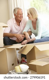 Senior Couple Moving Home And Packing Boxes