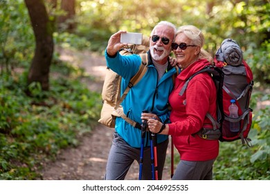 Senior couple in nature,walking through forest. Hiking. - Powered by Shutterstock