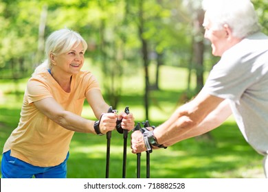 Senior Couple Nordic Walking In Park
