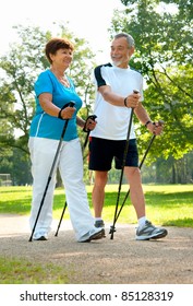 Senior Couple Nordic Walking In The Park