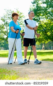 Senior Couple Nordic Walking In The Park