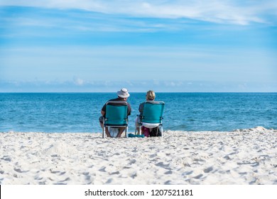 senior couple on the beach. Fat tourists, couple sitting on chairs on the beach and looking at the blue, turquoise sea - Powered by Shutterstock