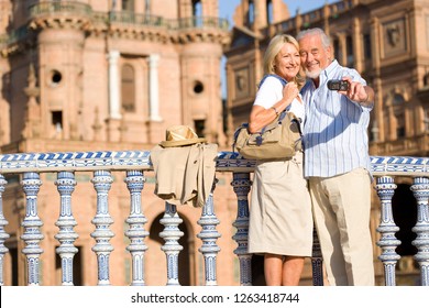 Senior Couple On City Break Vacation Taking Selfie With Camera