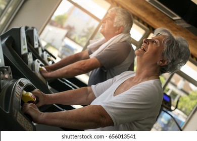 Senior Couple On Jogging Machine. Senior Couple Workout In The Gym. 