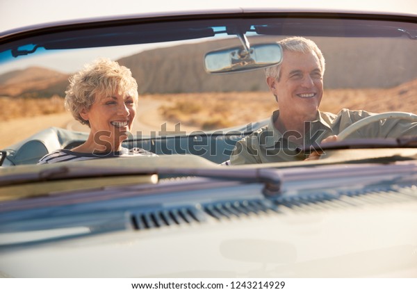 Senior couple on a US road trip, seen through\
car windscreen
