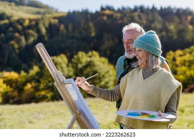 Senior couple painting together in nature, during autumn day. - Powered by Shutterstock